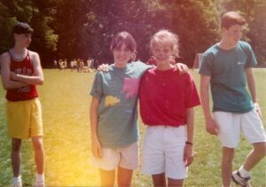 Four people at Upper Reynolds Field at what appears to be Field Day, circa 1992.